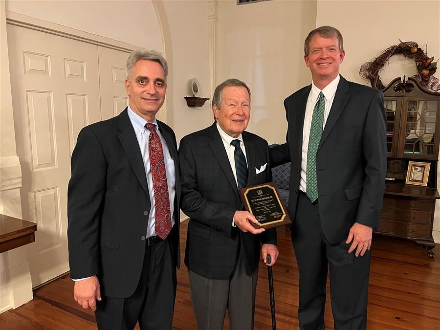  Mr. Greene stands with Dr. Mascia and Allen Cope to accept a plaque for his service. 